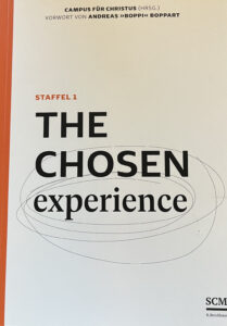Umschlag eines Buches mit dem Titel The Chosen Experience, Staffel 1, mit schwarzem und orangefarbenem Text auf weißem Hintergrund und kreisförmigen Skizzenlinien hinter dem Wort "chosen".